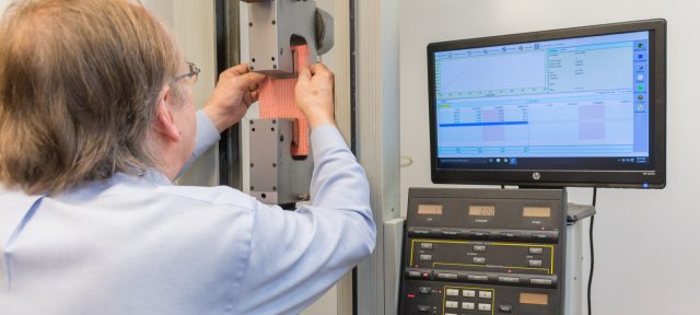 man performing grab tensile test at in-house lab