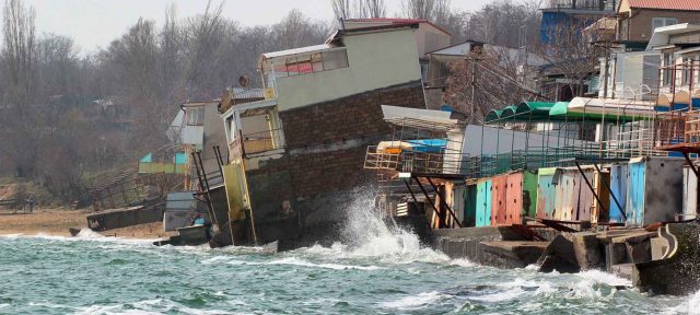 houses built on clay sliding down due to coastal erosion